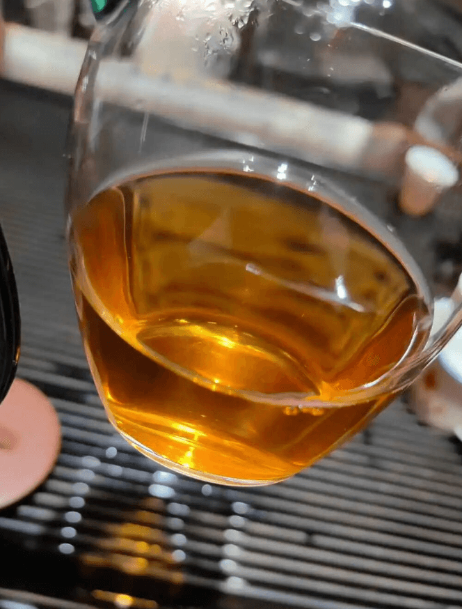Clear golden-orange Kunlu Mountain tea liquor in a glass fairness pitcher